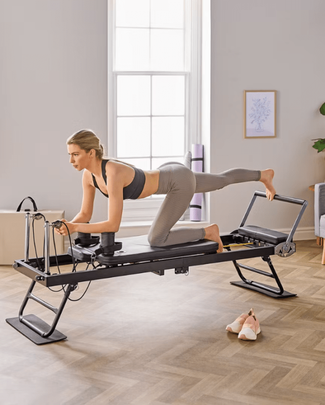 Model working out on Aldi Specialbuys reformer pilates machine
