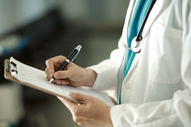 Doctor writing on clipboard