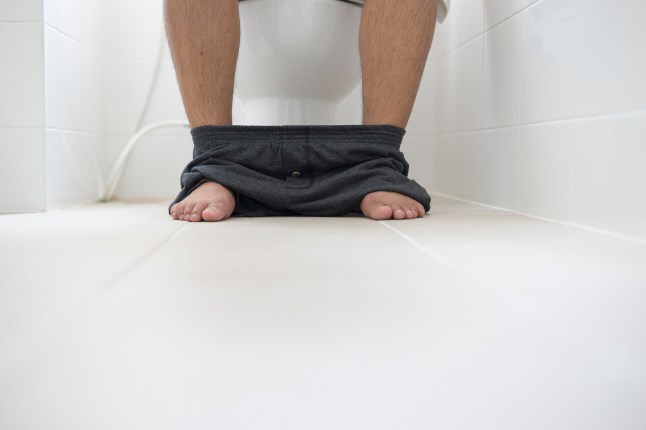 male sitting in toilet