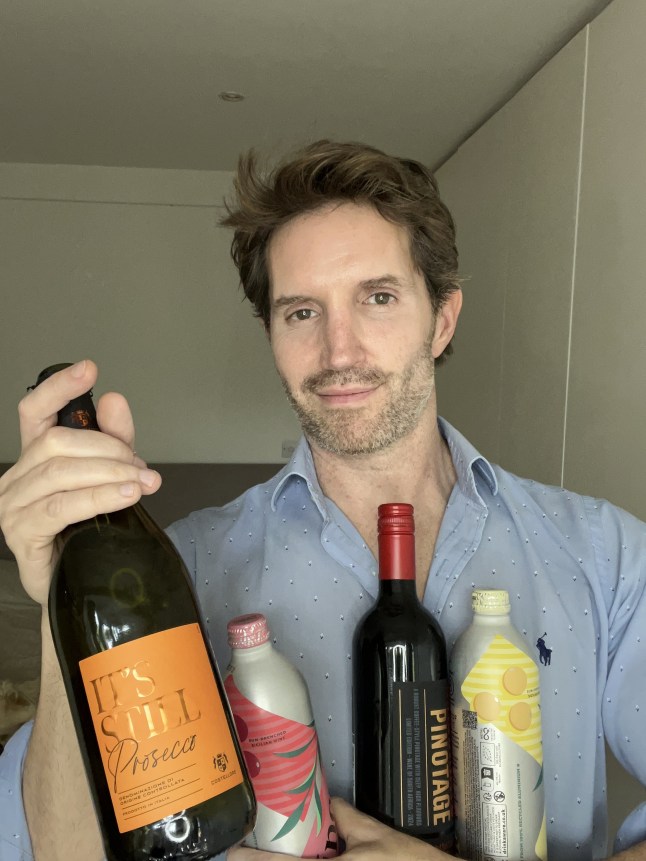 Rob Buckhaven holding bottles of wine, including Aldi's new Still Prosecco