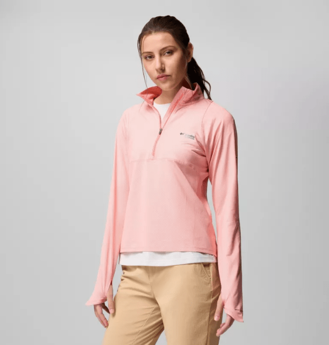 Female wearing ligh pink jumper with white tshirt and beige trousers