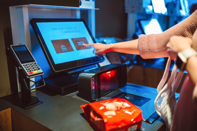 A shopper using self-checkout kiosk with eco-friendly choices in a retail store