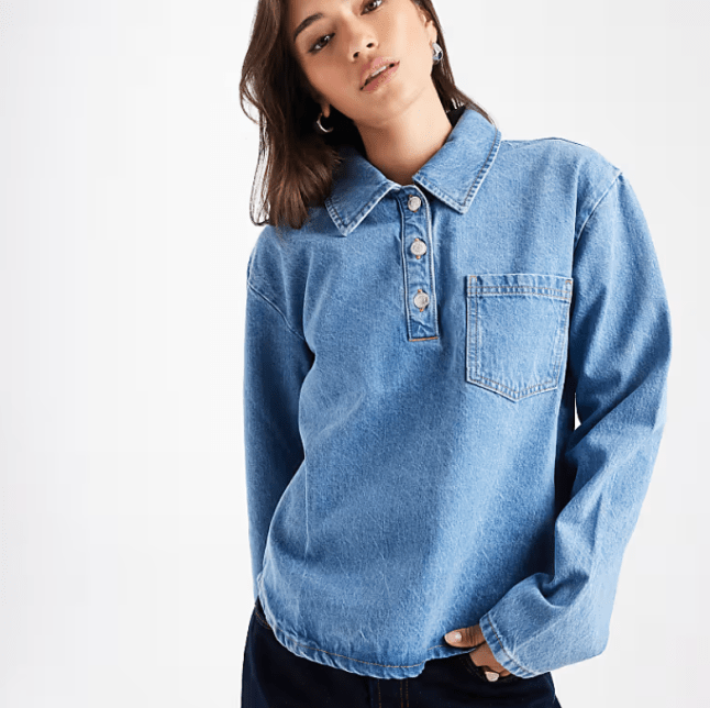 Female wears ASOS DESIGN Denim Button Down Rugby Top in Mid Blue