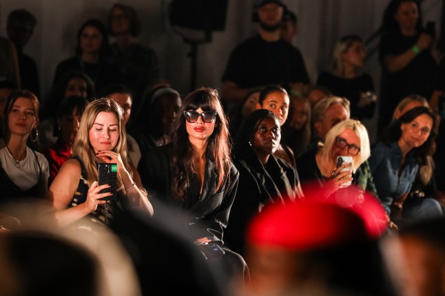 Females sit on the front row of a catwalk