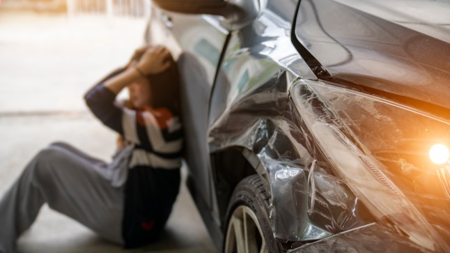 Stressed Driver Sitting At Roadside After Traffic Accident