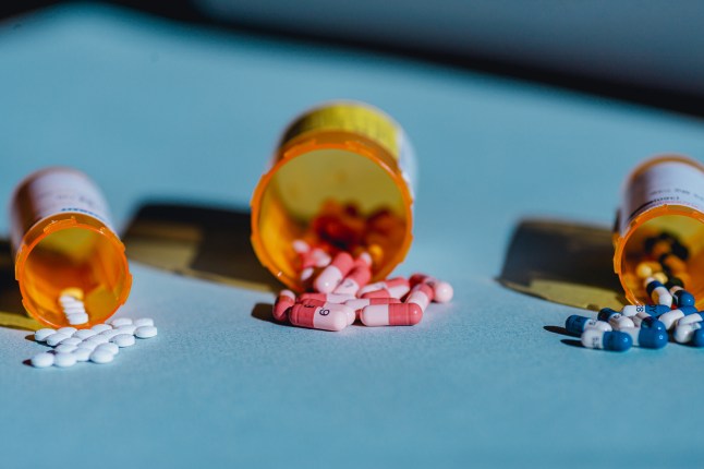 Open Pill Bottles and Medicine on Blue Background