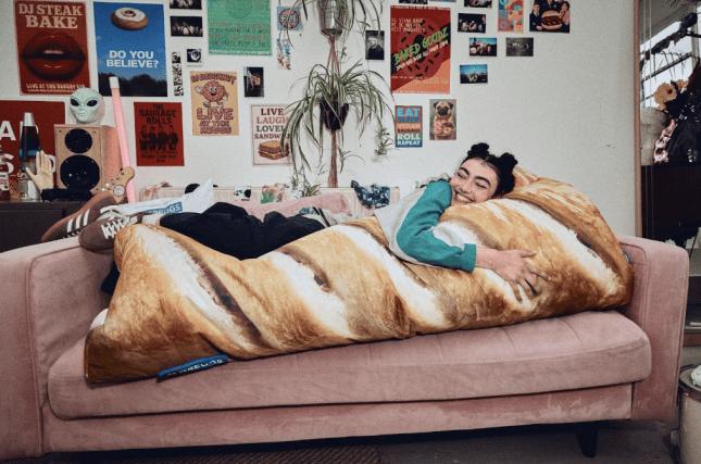 Female on the sofa with large sausage roll pillow