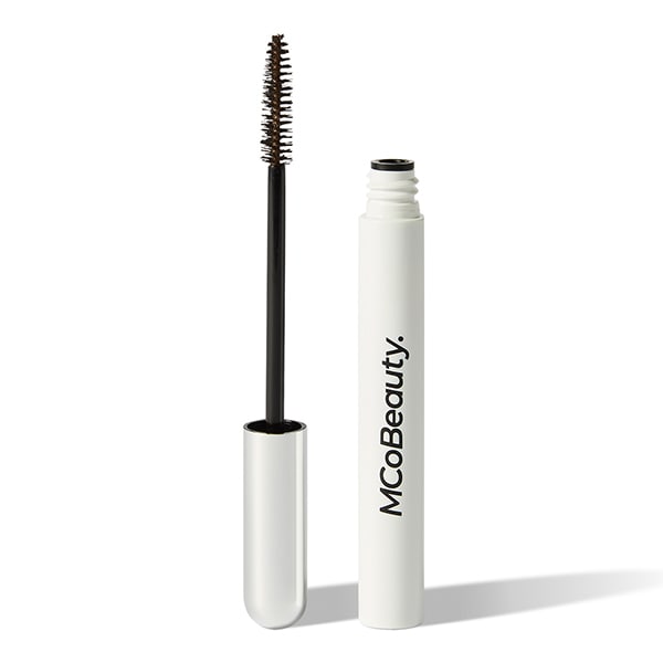 White tube with mascara wand next to it, that has a silver cap
