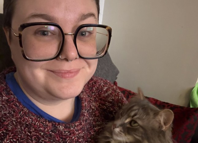 Emma Flint smiles in a selfie with with their cat