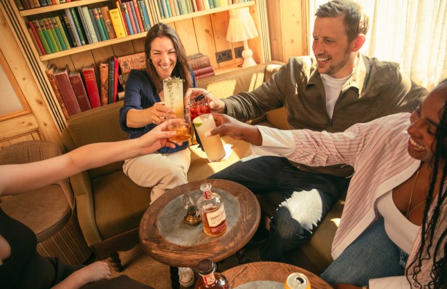 Group of people 'cheersing' together with Duppy Share, around a table