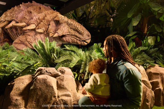 Man and small child admire dinosaurs at Tickets to Jurassic World: The Experience