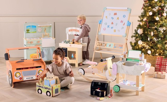 Children playing with the wooden toys from Aldi, including a wooden air fryer, car and kitchen