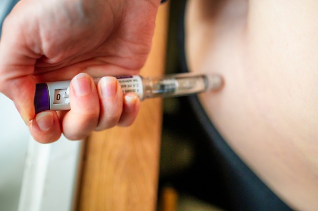 Woman using injection pen to administer weight loss drug