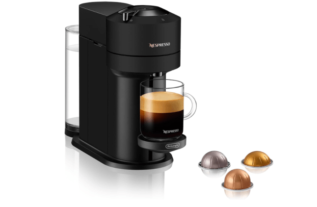 Black machine with mug of coffee and small pods