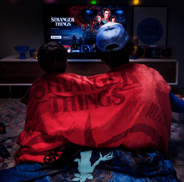 Young children wrapped in a slogan blanket