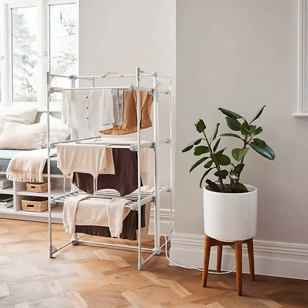 Livingroom with airer in the middle with clothing, hanging from it