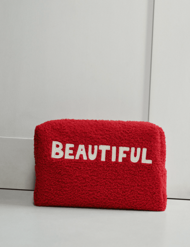 Red makeup bag with slogan across the front