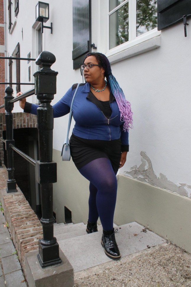 Female poses in outfit, wearing dark purple Snag tights