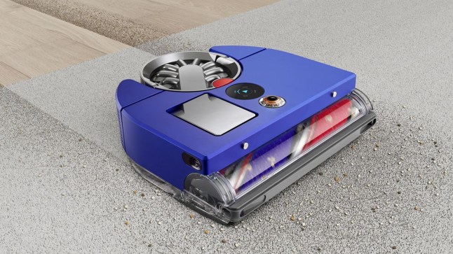 Blue robot vacuum cleaner clearing dirt