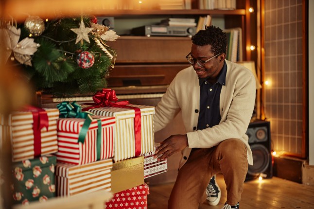 Man taking his gift under the Christmas tree