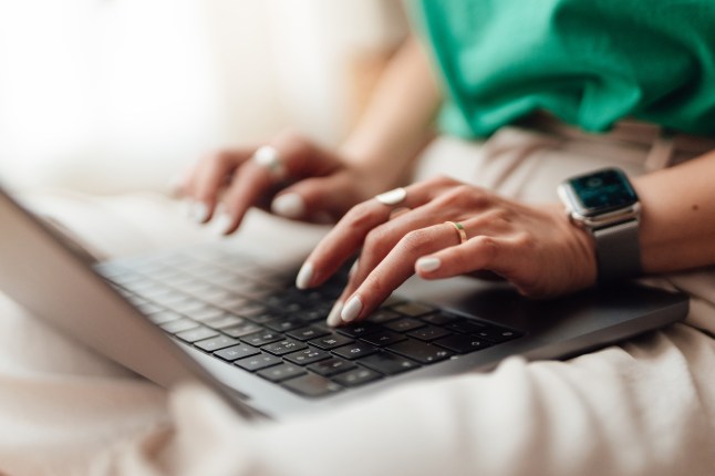Closeup of female hands typing on laptop keyboard