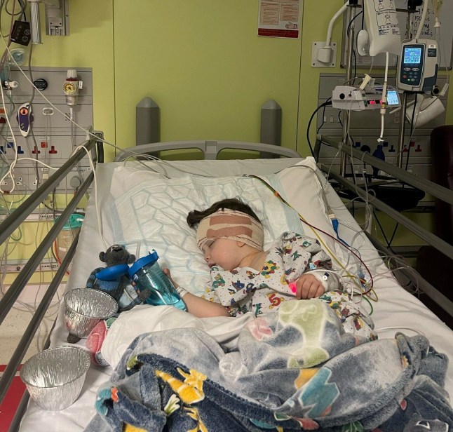 Raffi Starkowitz after surgery in hospital. A little boy has been diagnosed with a rare brain cancer after he was spotted "walking unsteadily" at nursery.Four-year-old Raffi Starkowitz was at nursery when he suddenly began unsteady on his feet and would lean to one side in March 2025. His parents Neil, 47, and Nicky, 46, were called and thought it was strange, and took him to A&E. An emergency MRI scan showed he had a space-invasion lesion, and he was rushed to Great Ormond Street Hospital, where he underwent a 10-hour operation to remove the mass on his brain. Photo released 19/11/2025