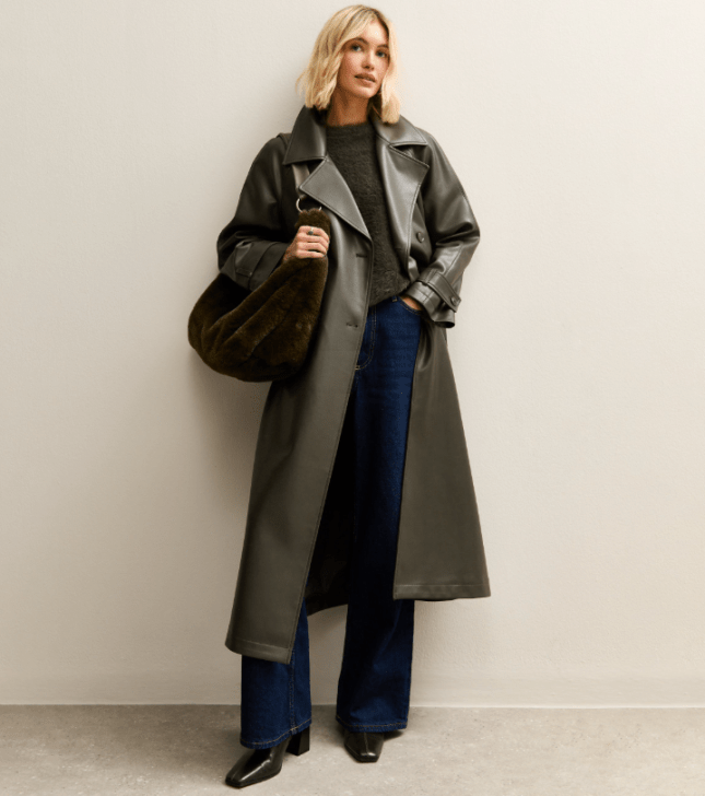 Model wears long, dark green trench coat