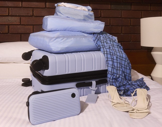 A selection ofNere products - including cases and packing cubes, sat on a bed.