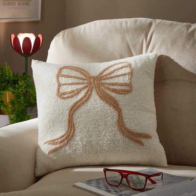 White pillow with beige bow on the front
