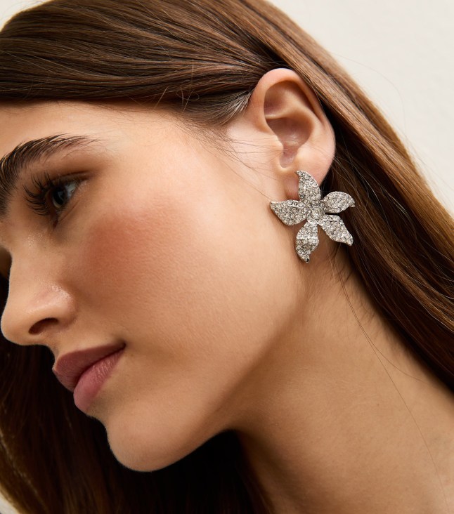 Female wears silver flower earring