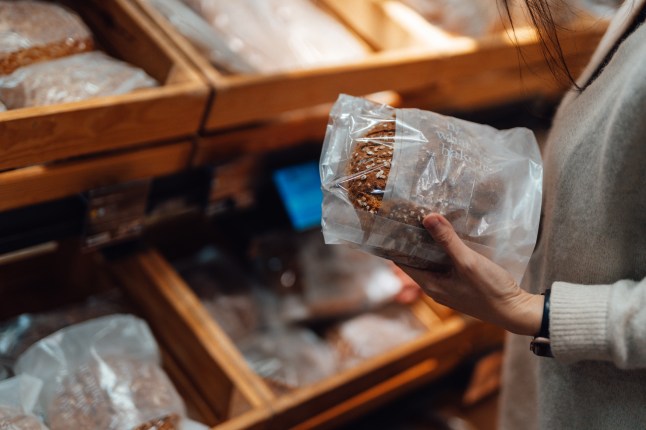 Young Woman Shopping Bread In Supermarket