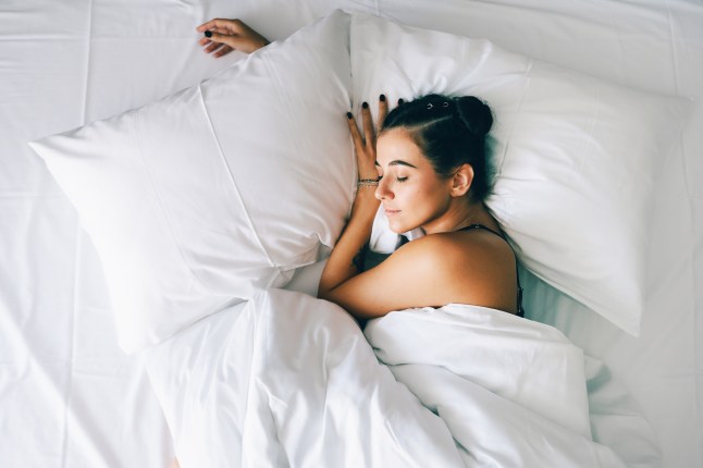 Exhausted woman sleeps in bed in the morning.