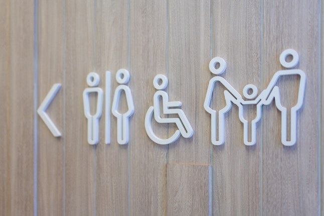 modern public toilet sign on the cement wall