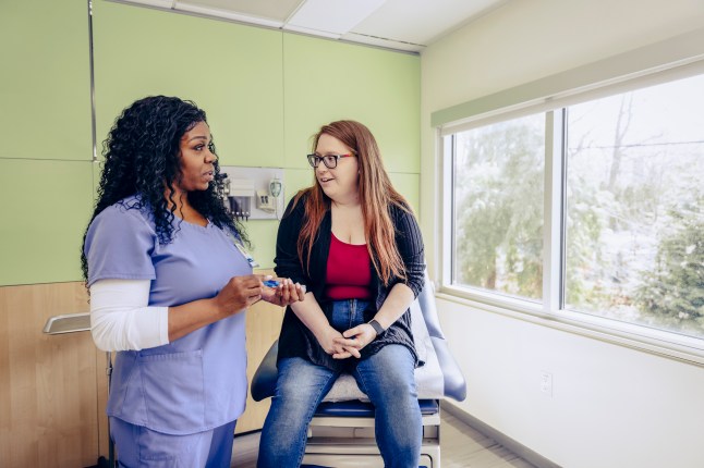Female medical professional talking with patient in exam room