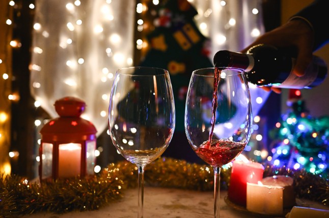 Pouring red wine into glasses during christmas celebration