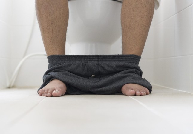 male sitting in toilet