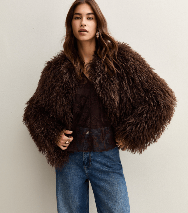 Female wears faux fur jacket with jeans