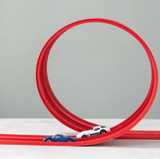 Red track for cars with small toy cards placed on top