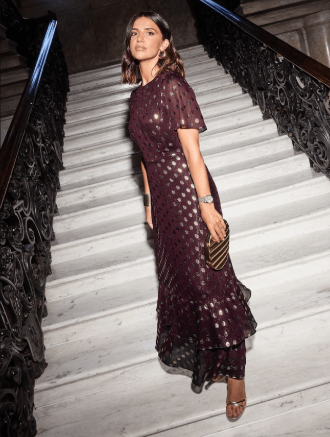 Female wears burgundy dress with gold detailing