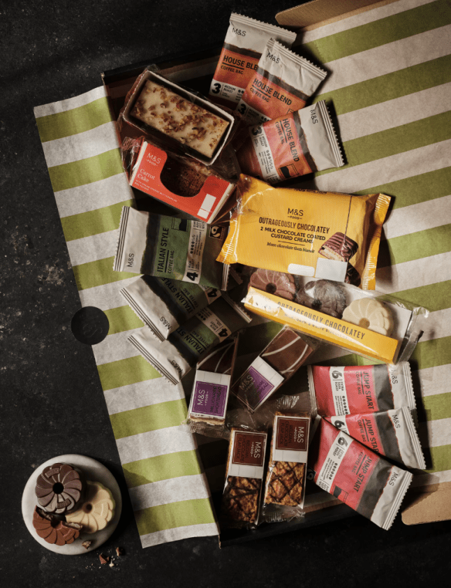Crisps, chocolate biscuits and snacks on a green and white stripe towel