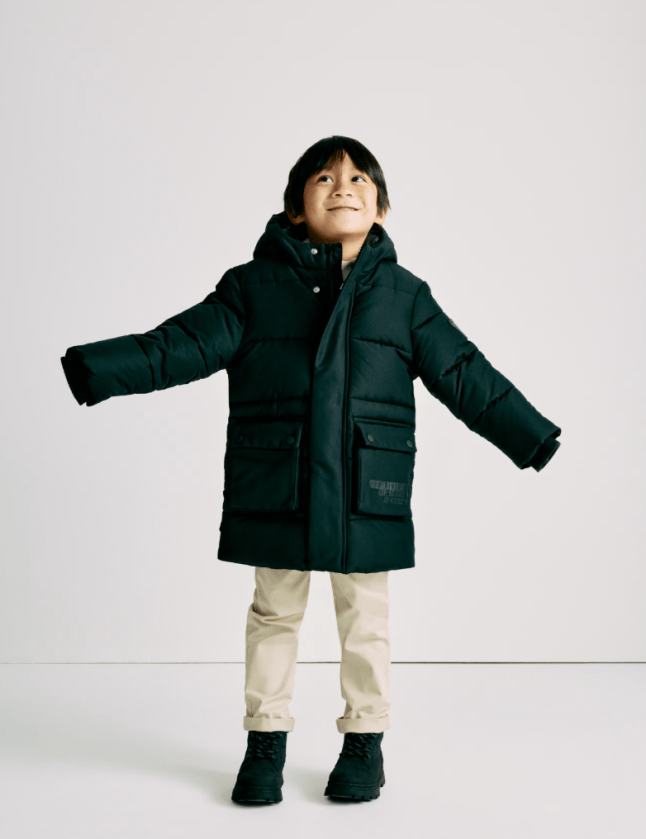Small boy wearing black padded coat