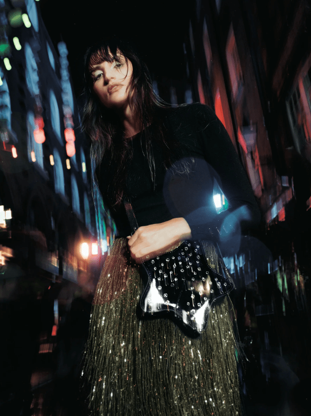 Female wears black star studded bag