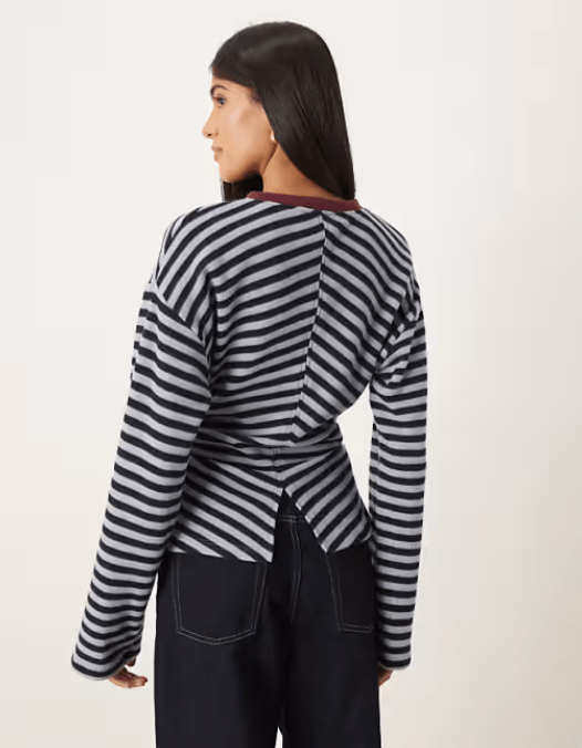 Female shows off back detail of stripe top