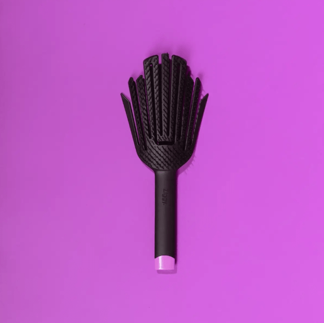Black hairbrush on purple background