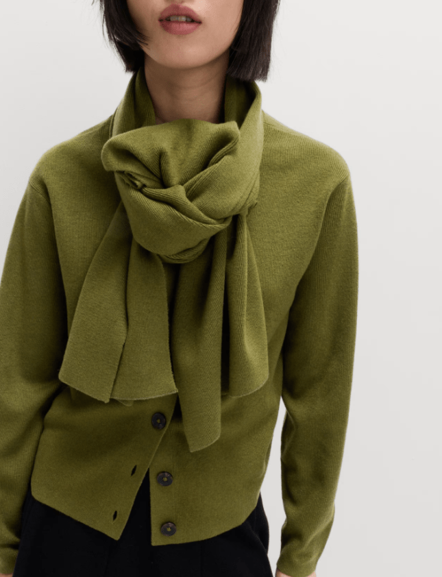 Female wears green jumper with scarf attached