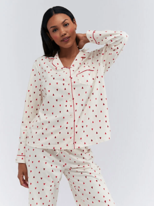 Female wears white pjs with red hearts printed all over