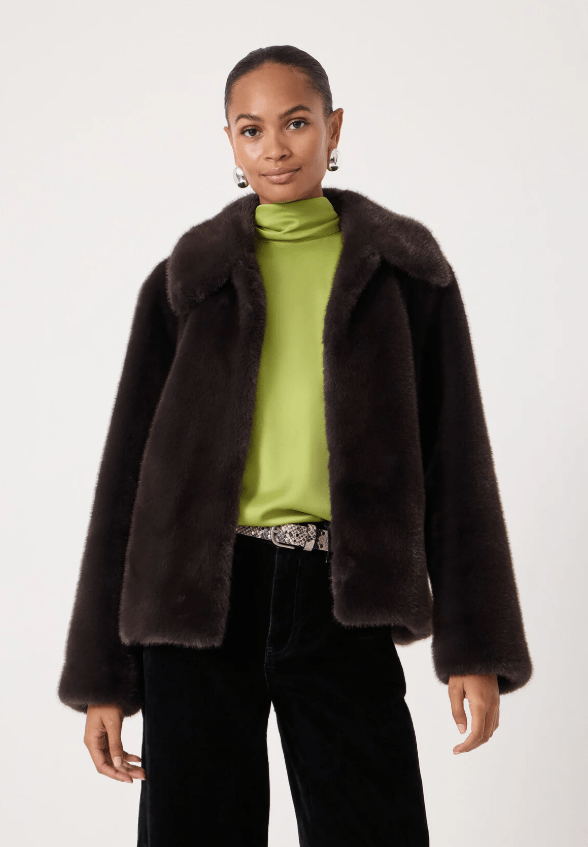 Female wears brown faux jacket with green silk shirt