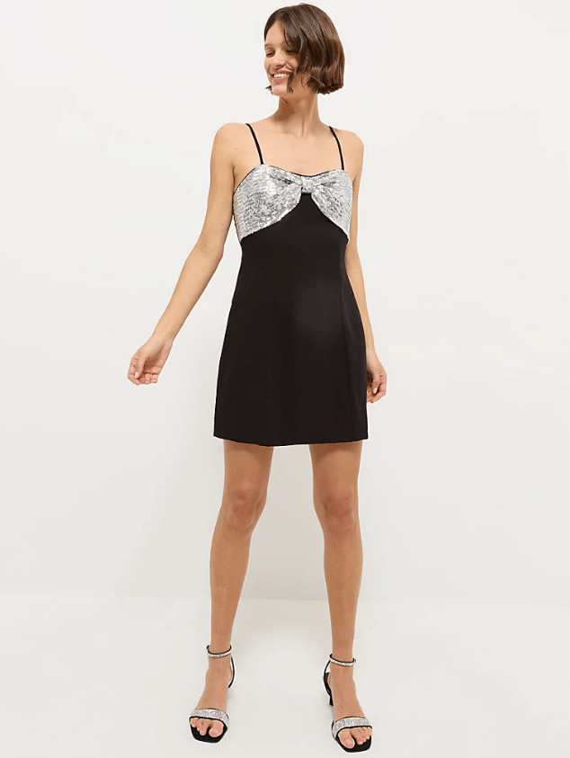 Female wears black dress with oversized silver bow