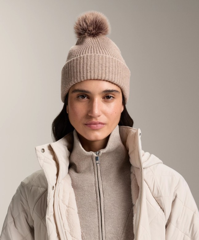 Female wears beige knitted bobble hat