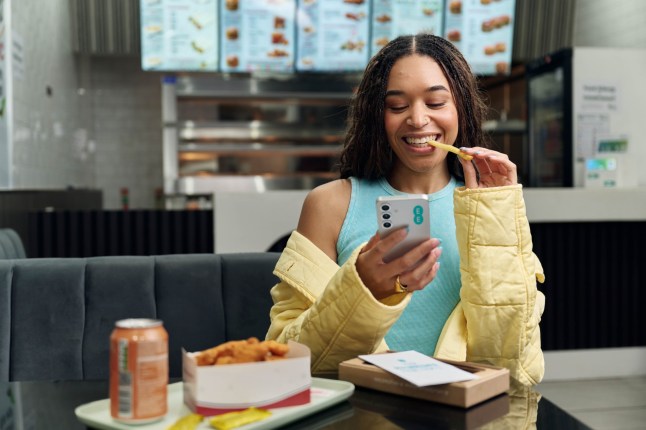 Female on phone, eating food